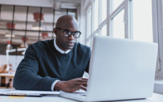 Young web designer sitting at his desk working.